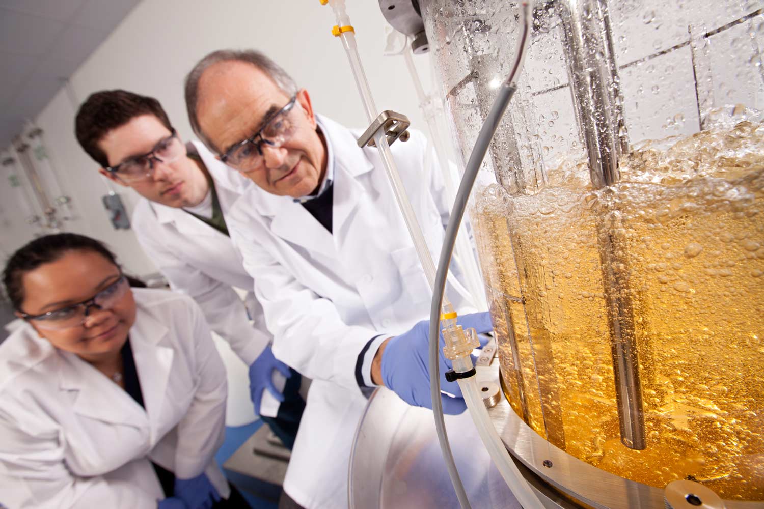 ϲʹ̳ professor and student researchers watch an experiment in action